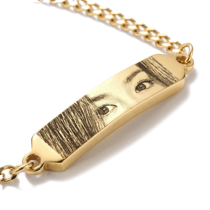 Close-up of the eye engraving on the gold bracelet bar