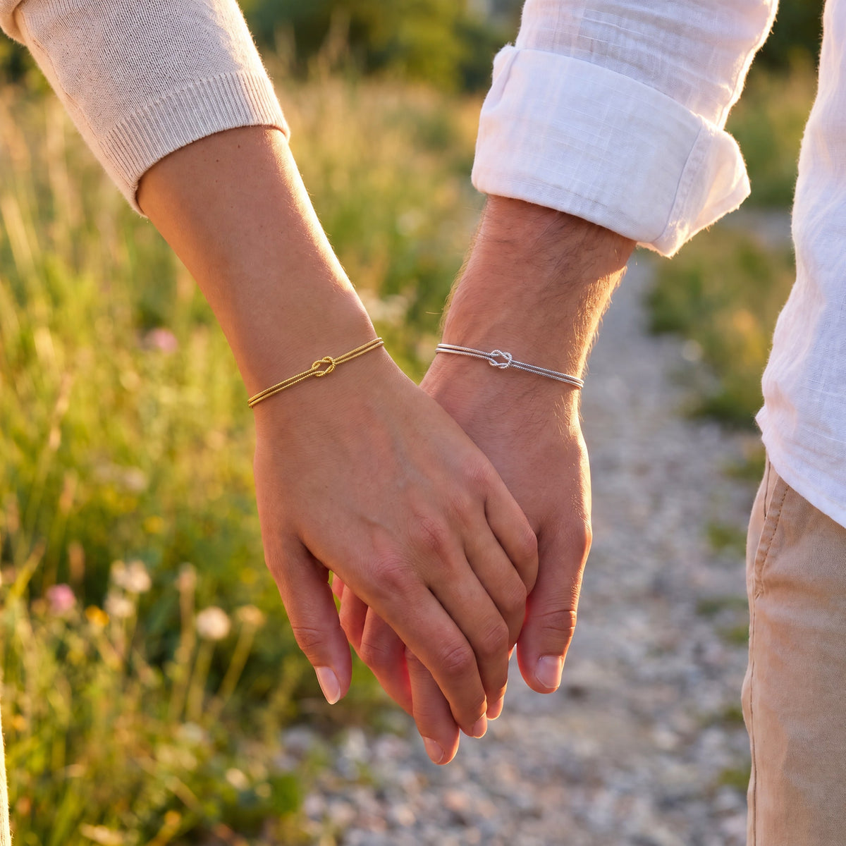 Forever Knot Bracelet – Gold & Silver – worn by a couple holding hands